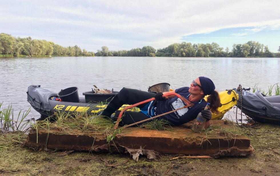 Frau posiert mit gesammelten Müll